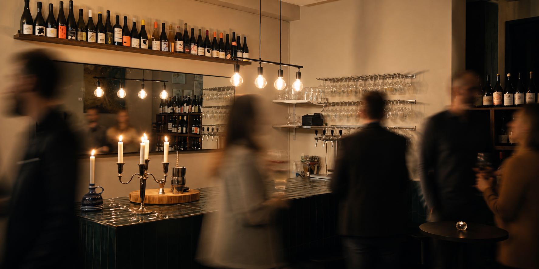 Inside BISe wine bar in Malmö — candlelit counter with shelves of wine bottles.